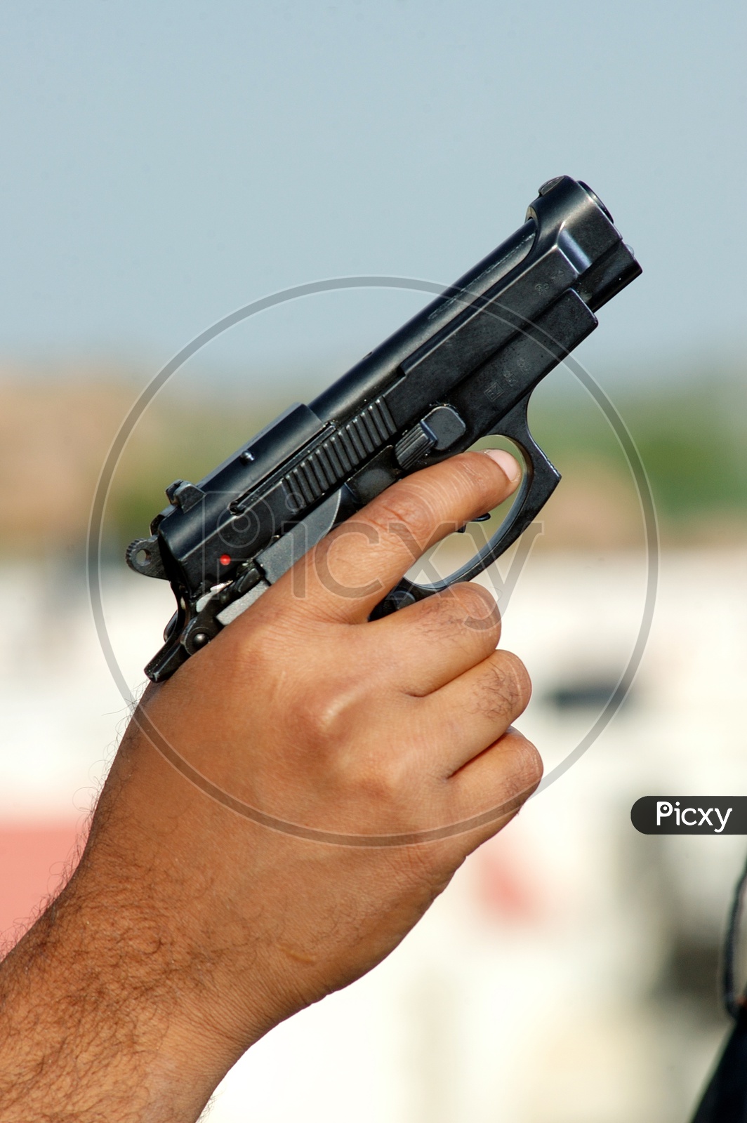 A man holding a black pistol