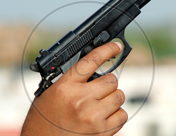 A man holding a black pistol