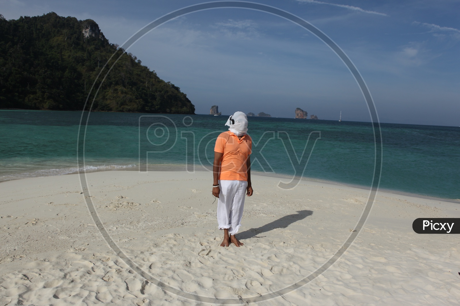 A man with white cloth face mask, dancing at the beach