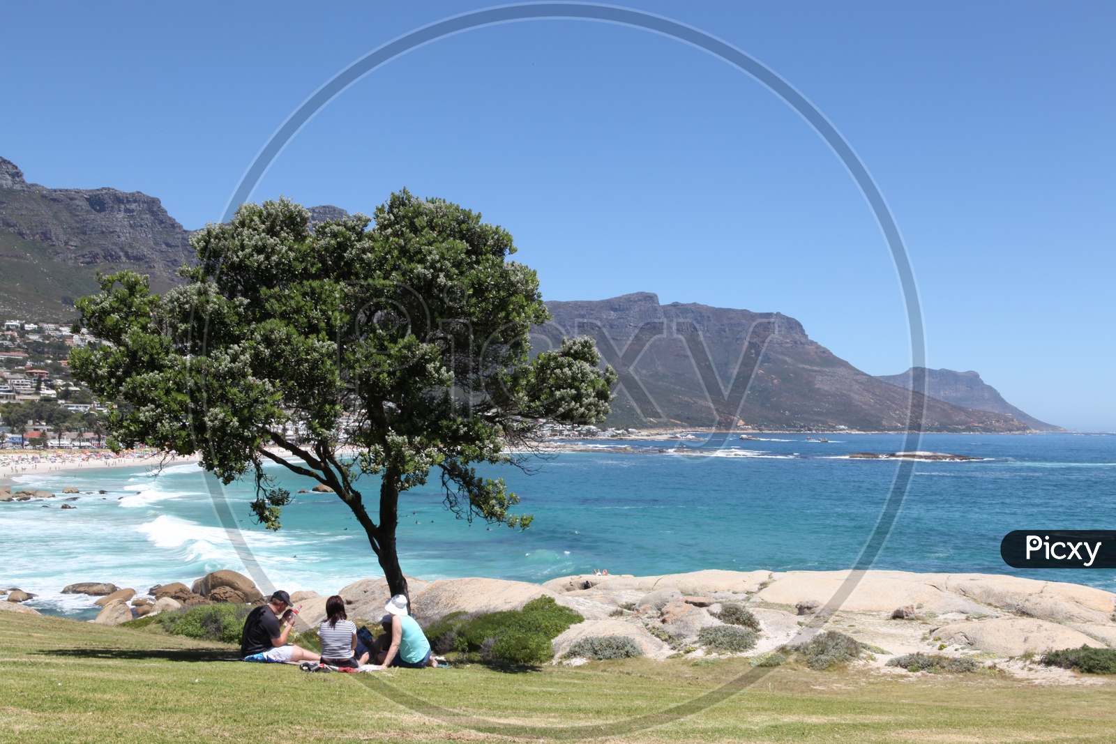 Tourists resting alongside the camps bay
