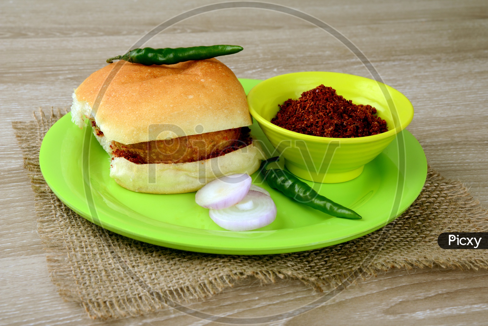 Vada pav with chutney, chilly and onion slices