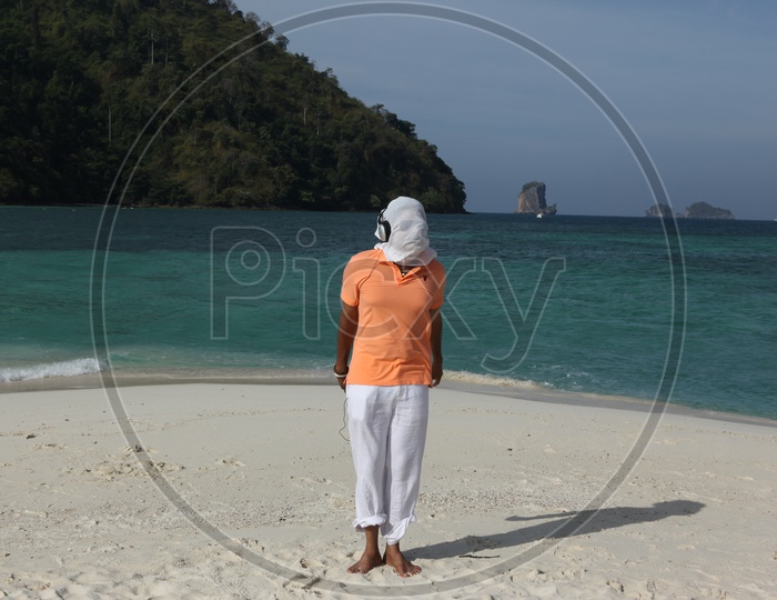 A man white cloth face mask, dancing at the beach