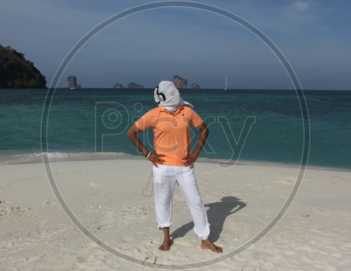 A man white cloth face mask, posing at the beach