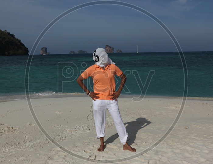 A man white cloth face mask posing at the beach