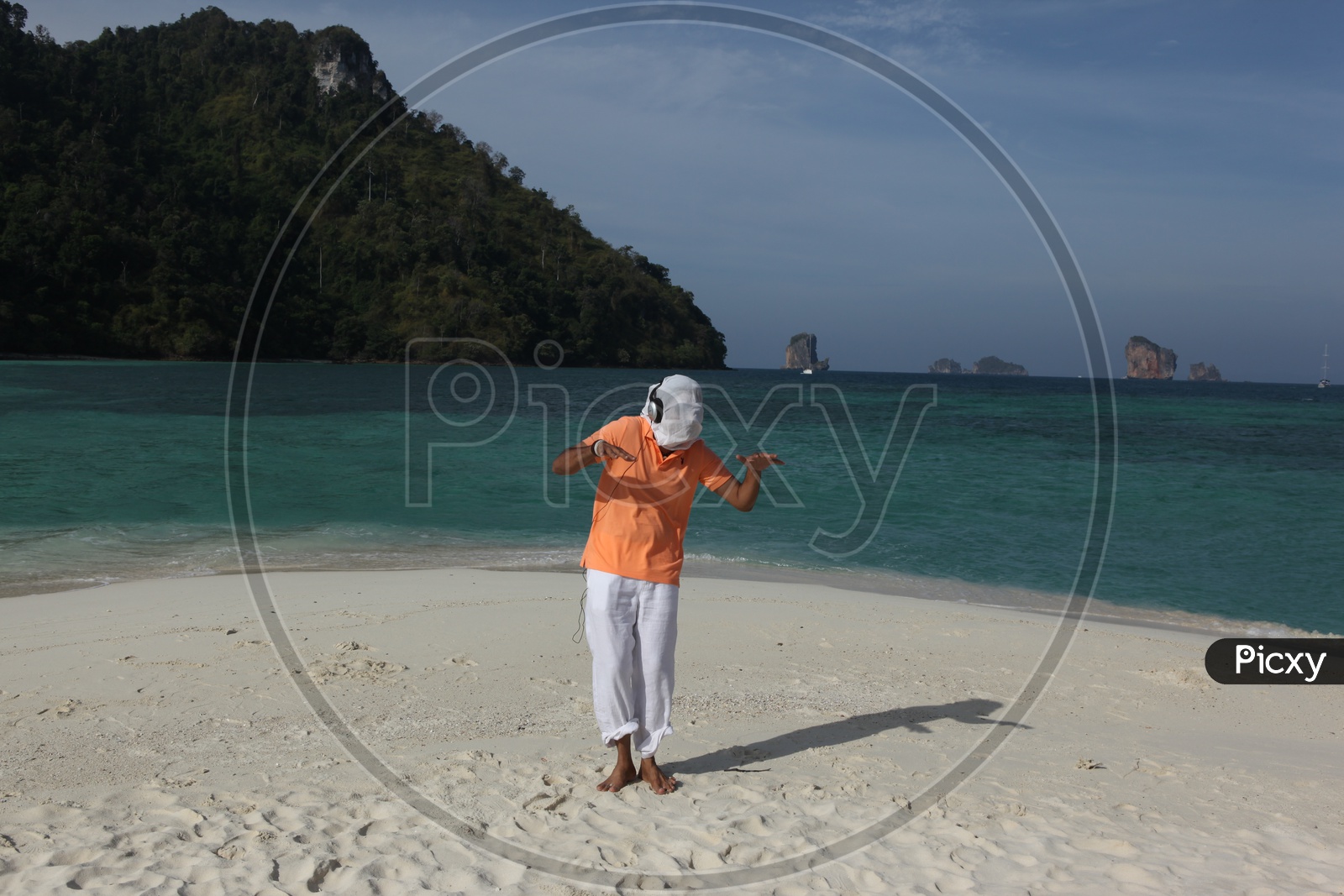 A man white cloth face mask, dancing at the beach