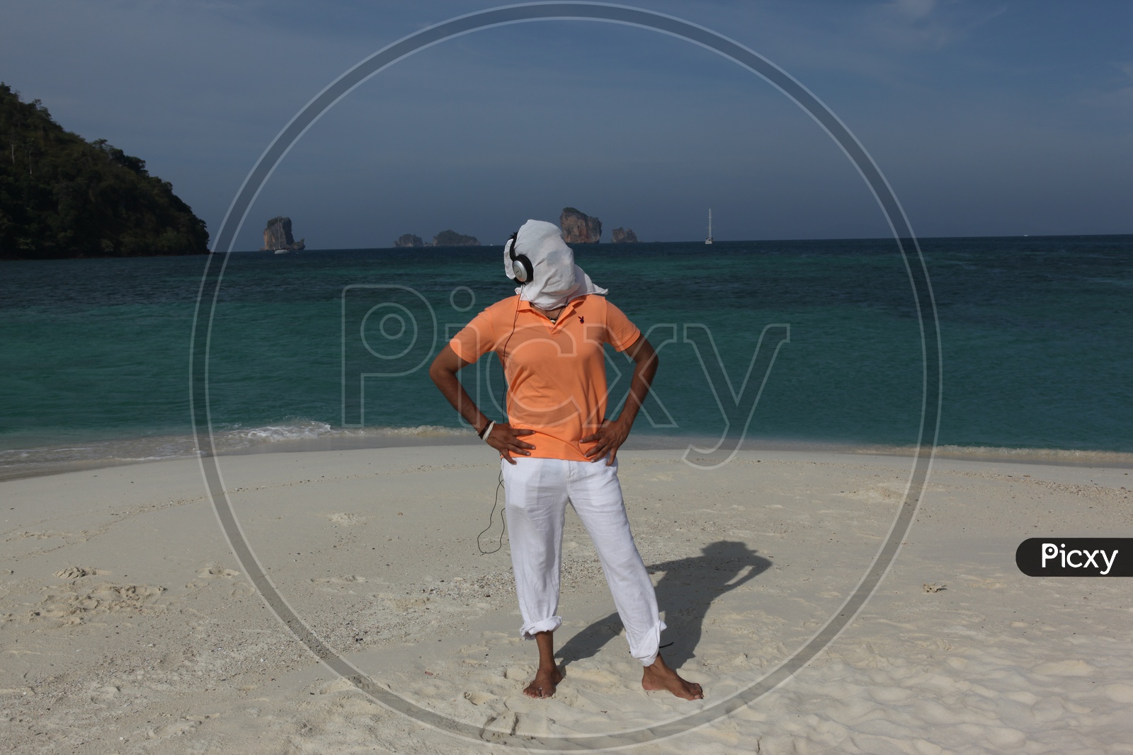 A man white cloth face mask posing at the beach