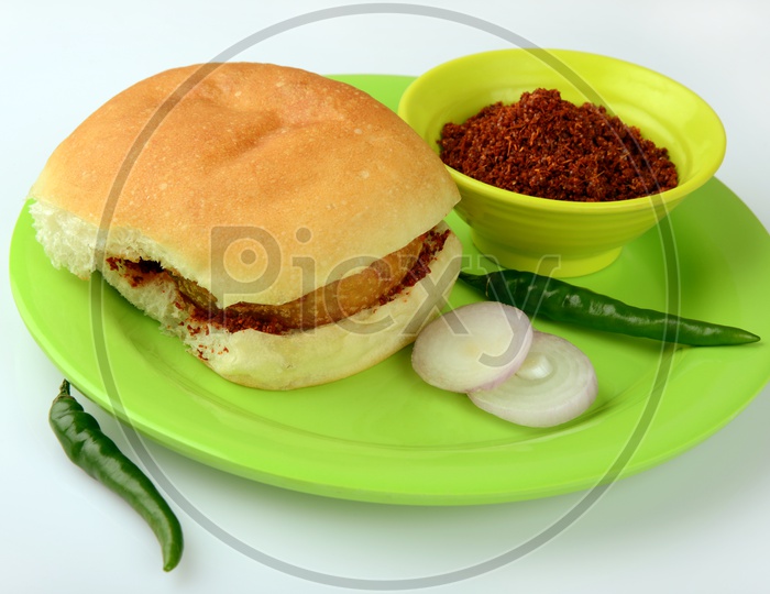 Vada pav with chutney, chilly and onion slices