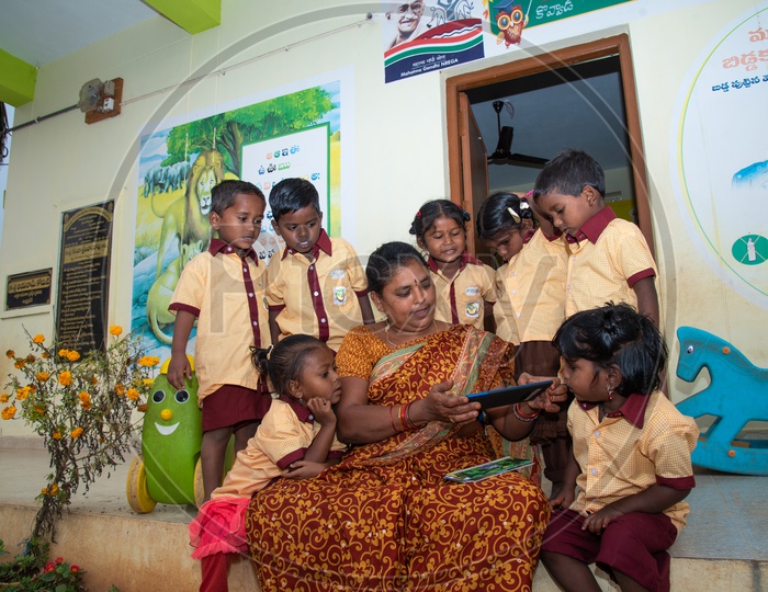 Anganwadi teacher demonstrating stories to the students using a tablet