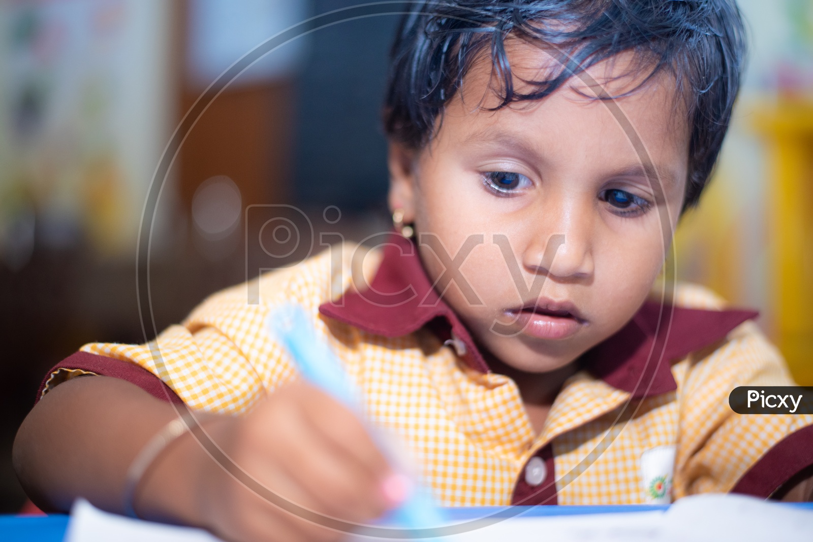 Student writing on a book at an Anganwadi center