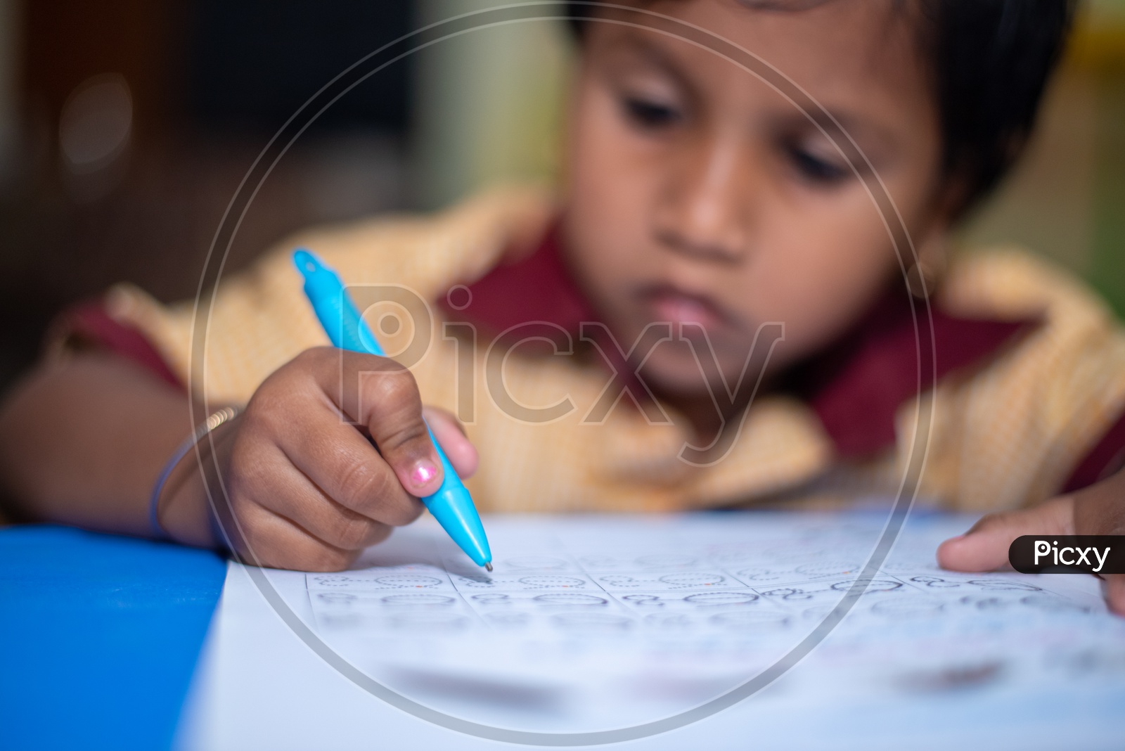 Student writing on a book at an Anganwadi center