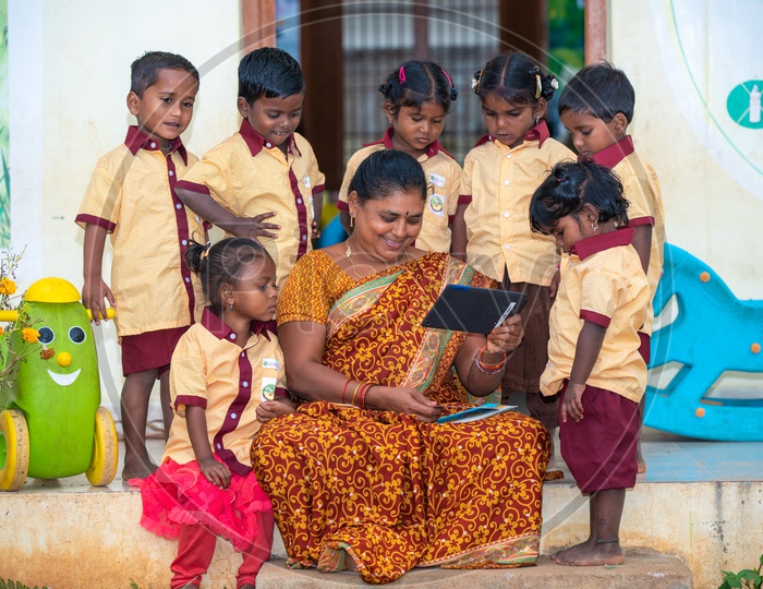 Anganwadi teacher demonstrating stories to the students through a tablet