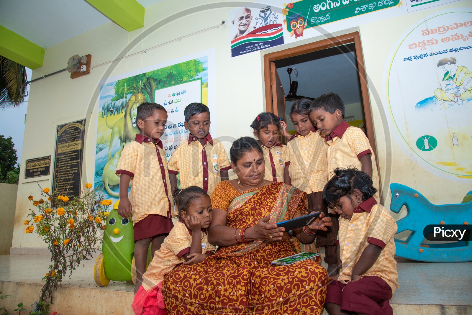 An Anganwadi teacher demonstrating stories to the students using a tablet