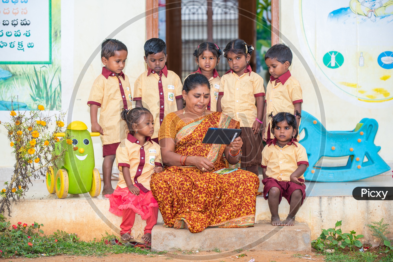 Anganwadi teacher demonstrating stories to the students through a tablet