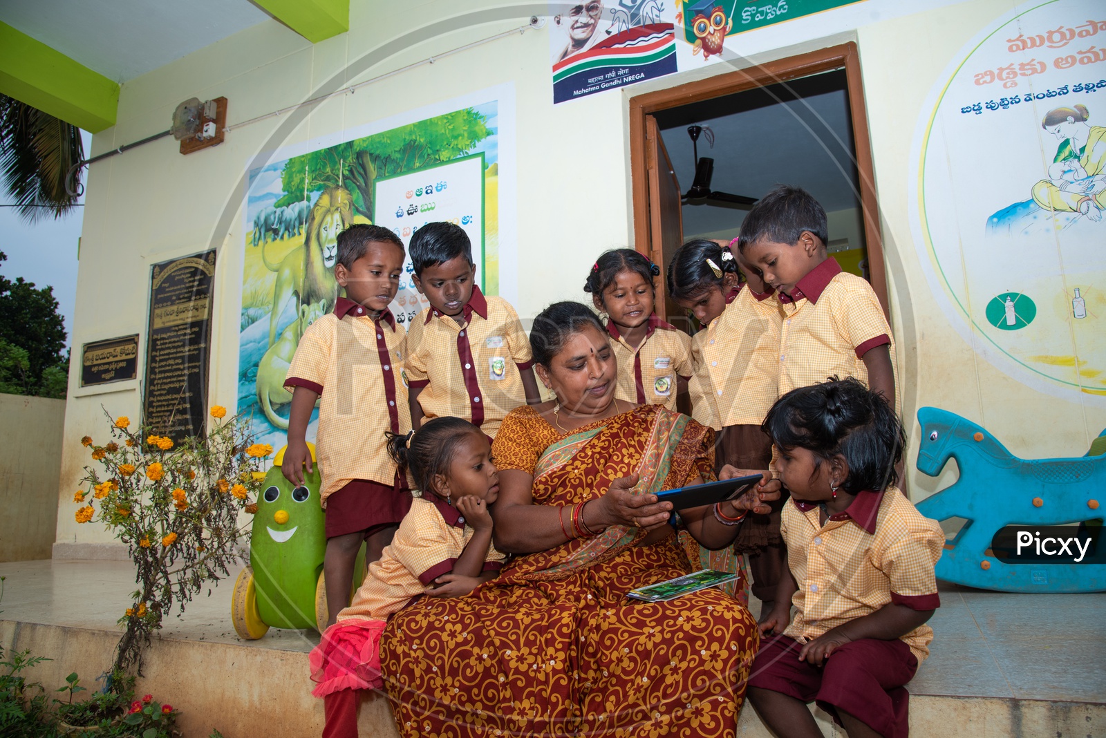 Anganwadi teacher demonstrating stories to the students using a tablet
