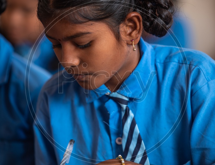 Primary government school student writing on a book
