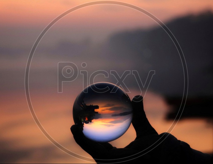 Sunrise on bank of Yamuna river through glass ball