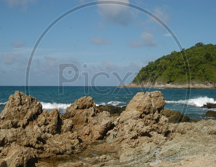 Waves and Rocks on the seashore with the mountains in the background