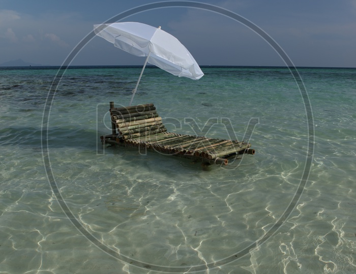 Bamboo pool chair with a white umbrella in the beach