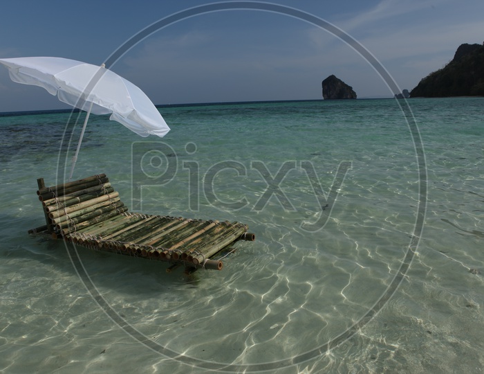 Bamboo pool with an white umbrella in the beach