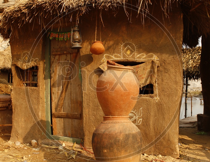 Clay pots in front of a thatched mud hut
