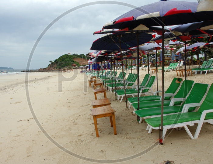 Pool chairs with umbrellas on the beach shore