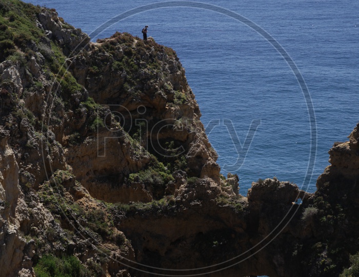 A person standing on the top of the cliff