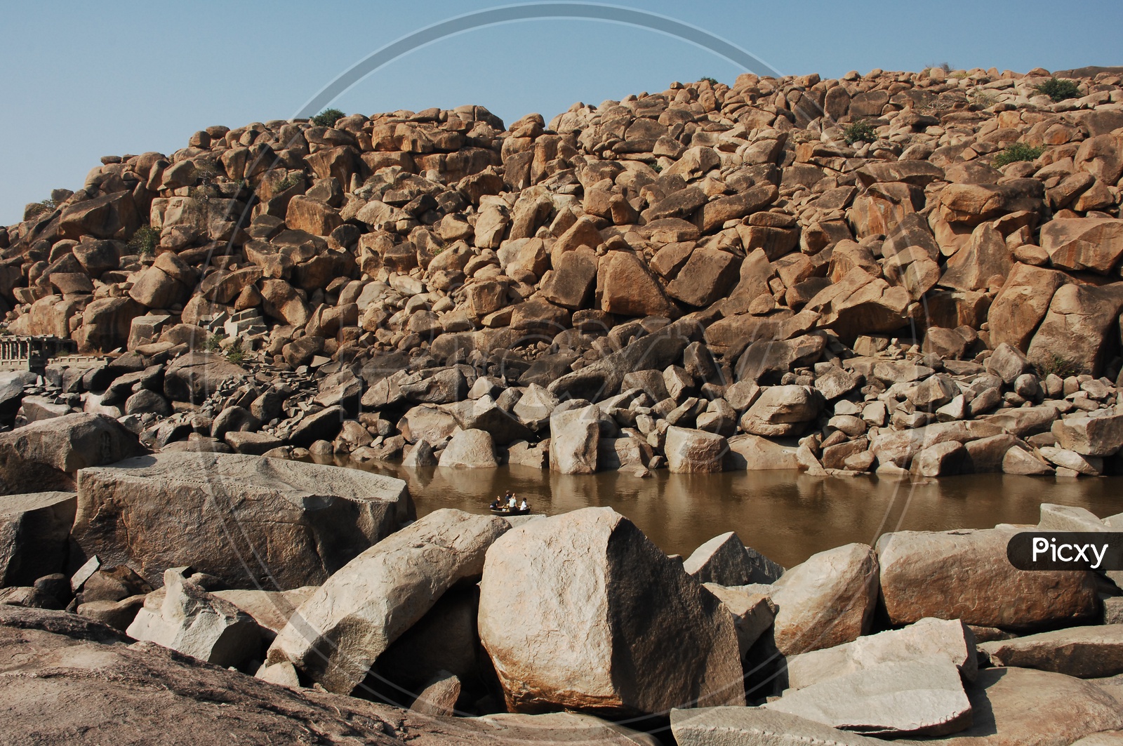 large rocks in an open area and water beside