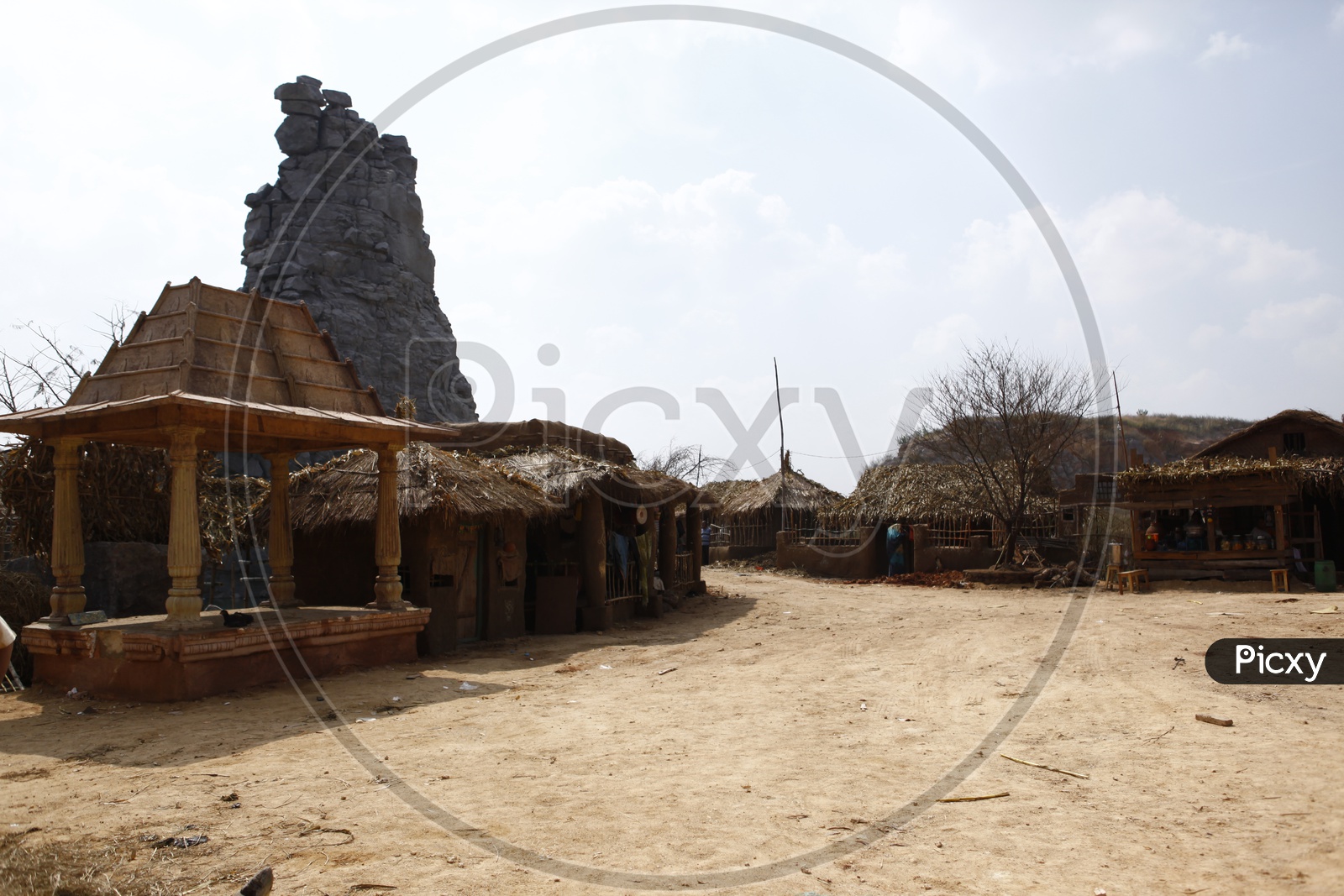 Small Mandapa and thatched mud huts in a village