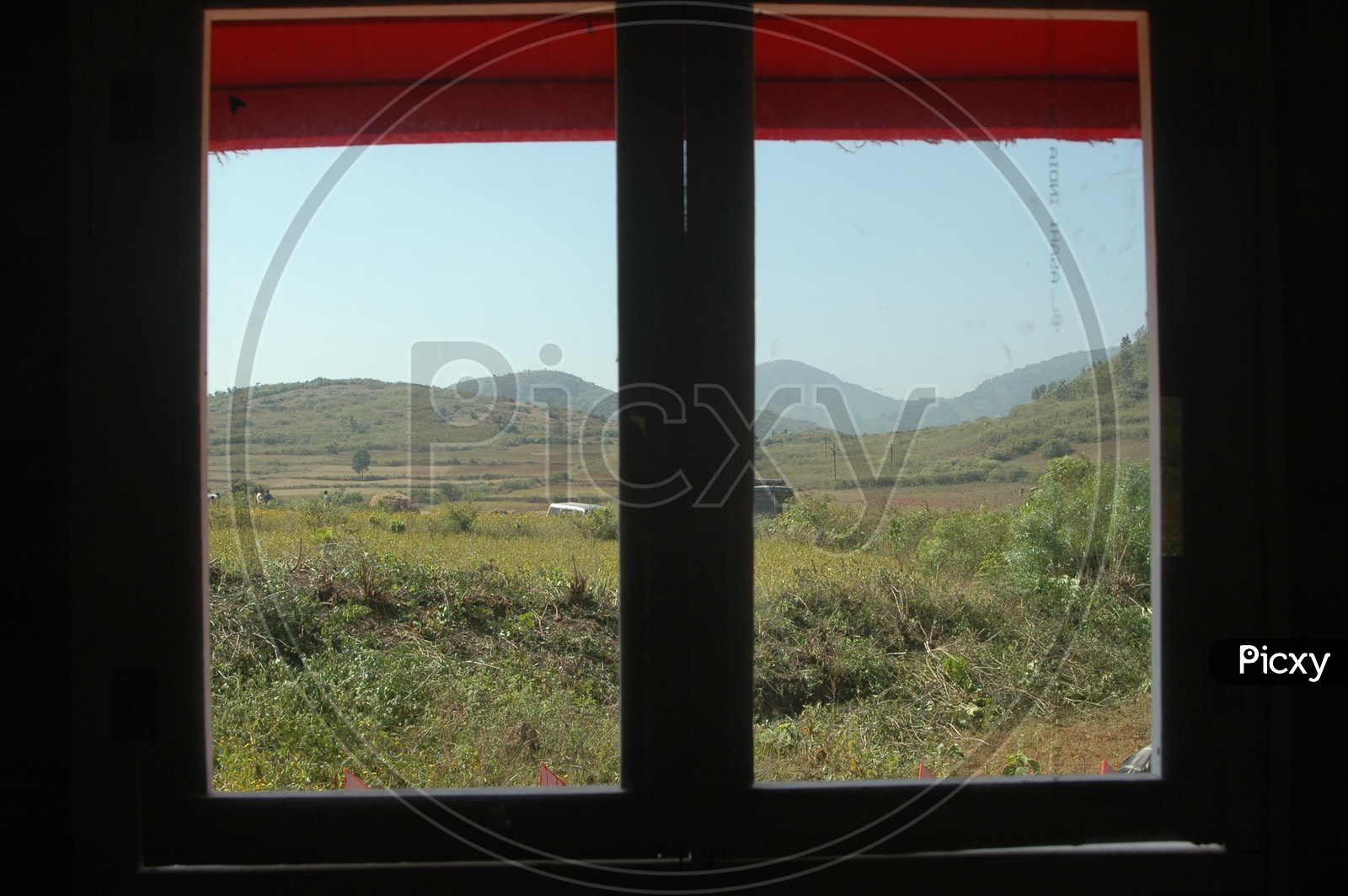 View of the fields in the valley through a glass window