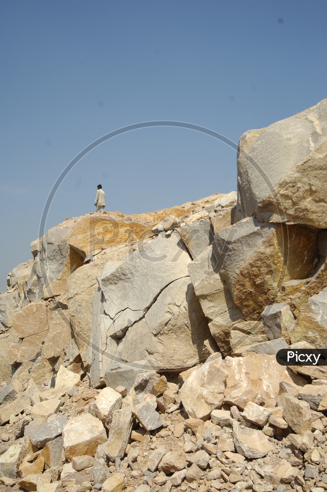 Man standing on top of the Granite boulder quarry