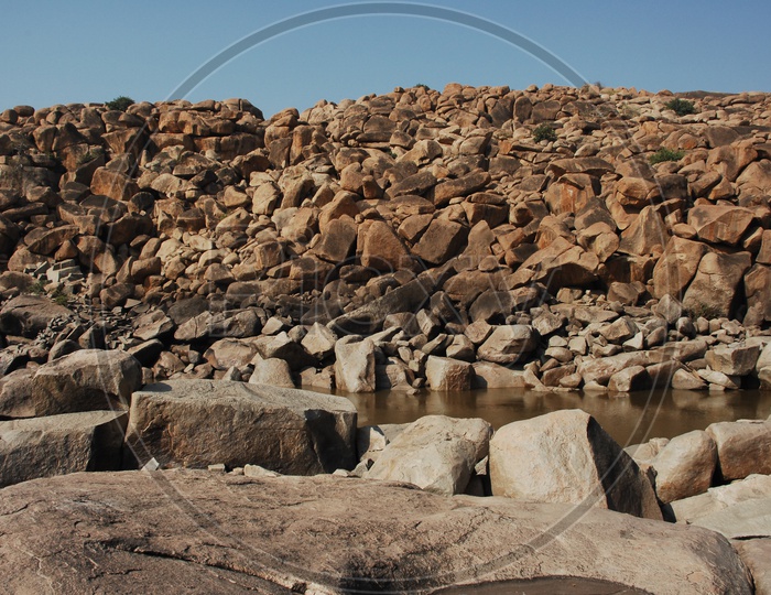 large rocks in an open area and water