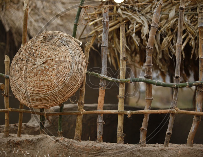 Bamboo woven basket hanged on a boundary wall
