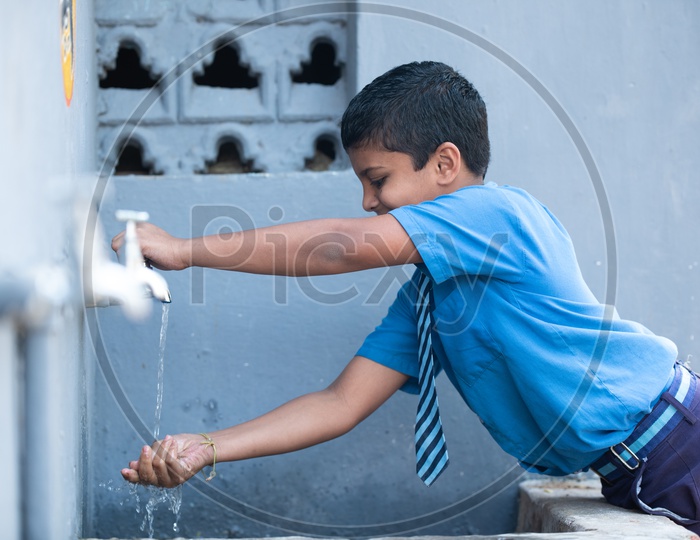 Government primary school student washing his hands at hand wash station