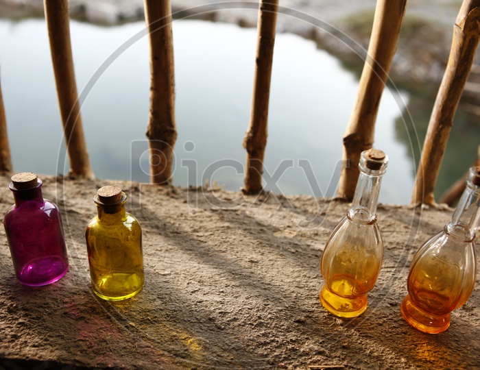 Colored glass bottles on wooden sill