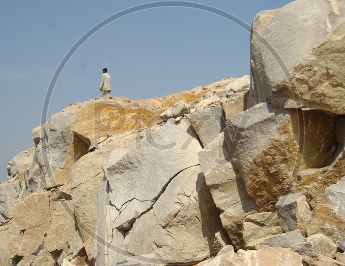 Man standing on top of the Granite boulder quarry