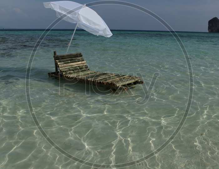 Bamboo pool with an white umbrella in the beach