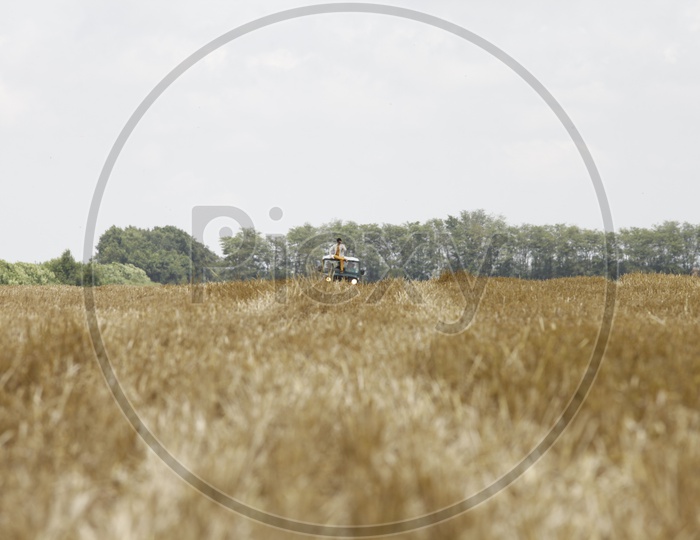 Man sitting on the jeep in the dried up fields