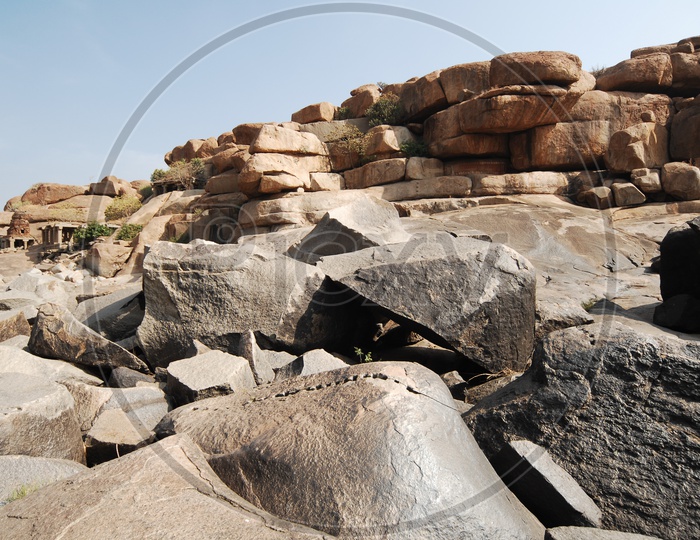 various shapes of rocks in a open area with a temple