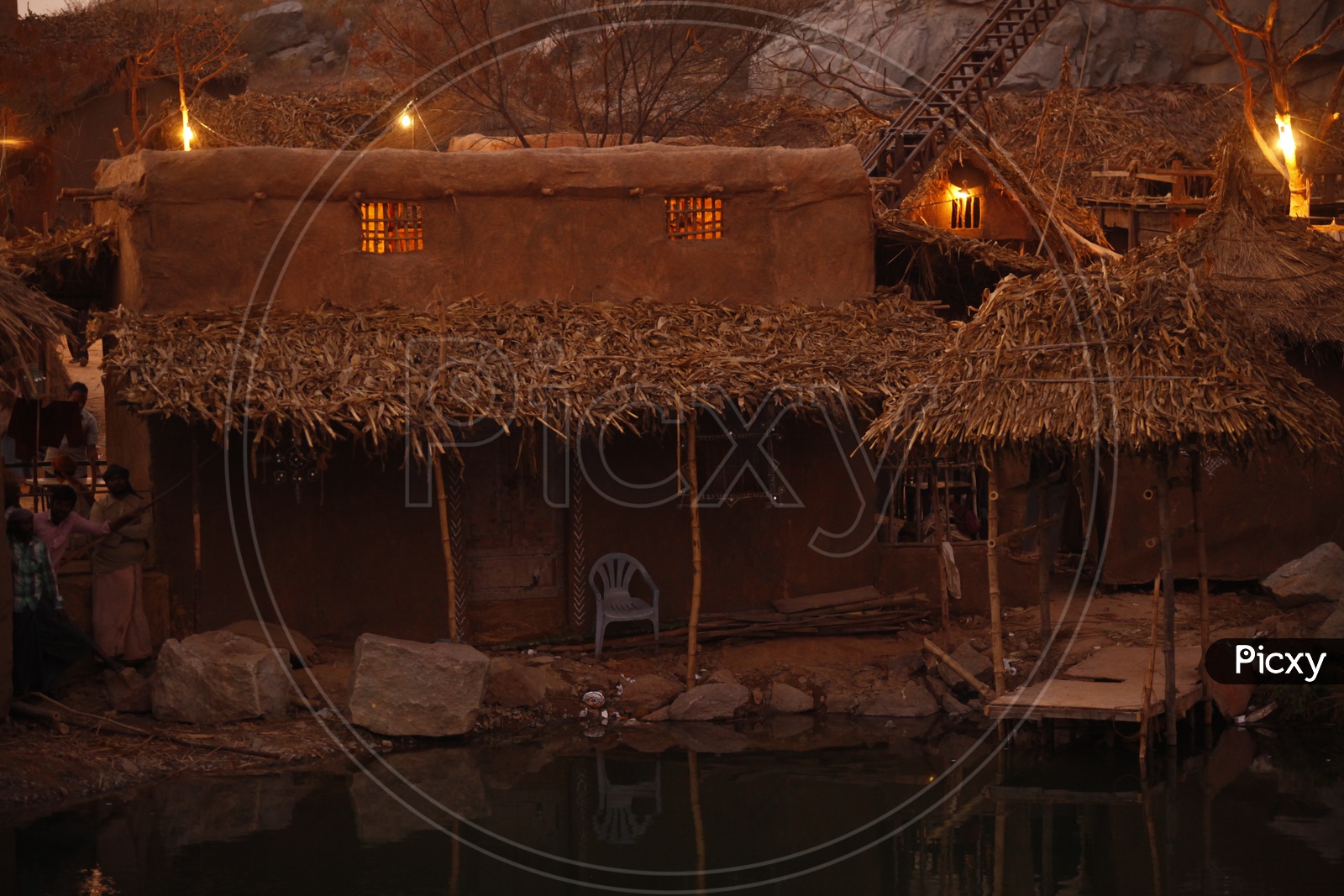 Thatched mud huts near a pond
