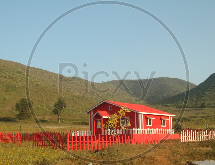 A red colored farm house in the fields of Araku valley