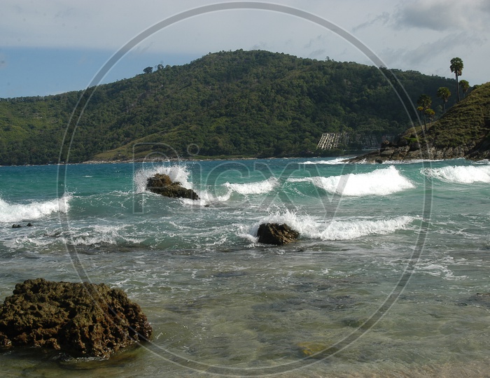Waves and Rocks on the seashore with the mountains in the background