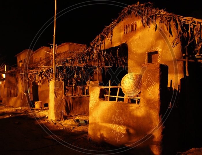 Thatched mud huts in a village during night time