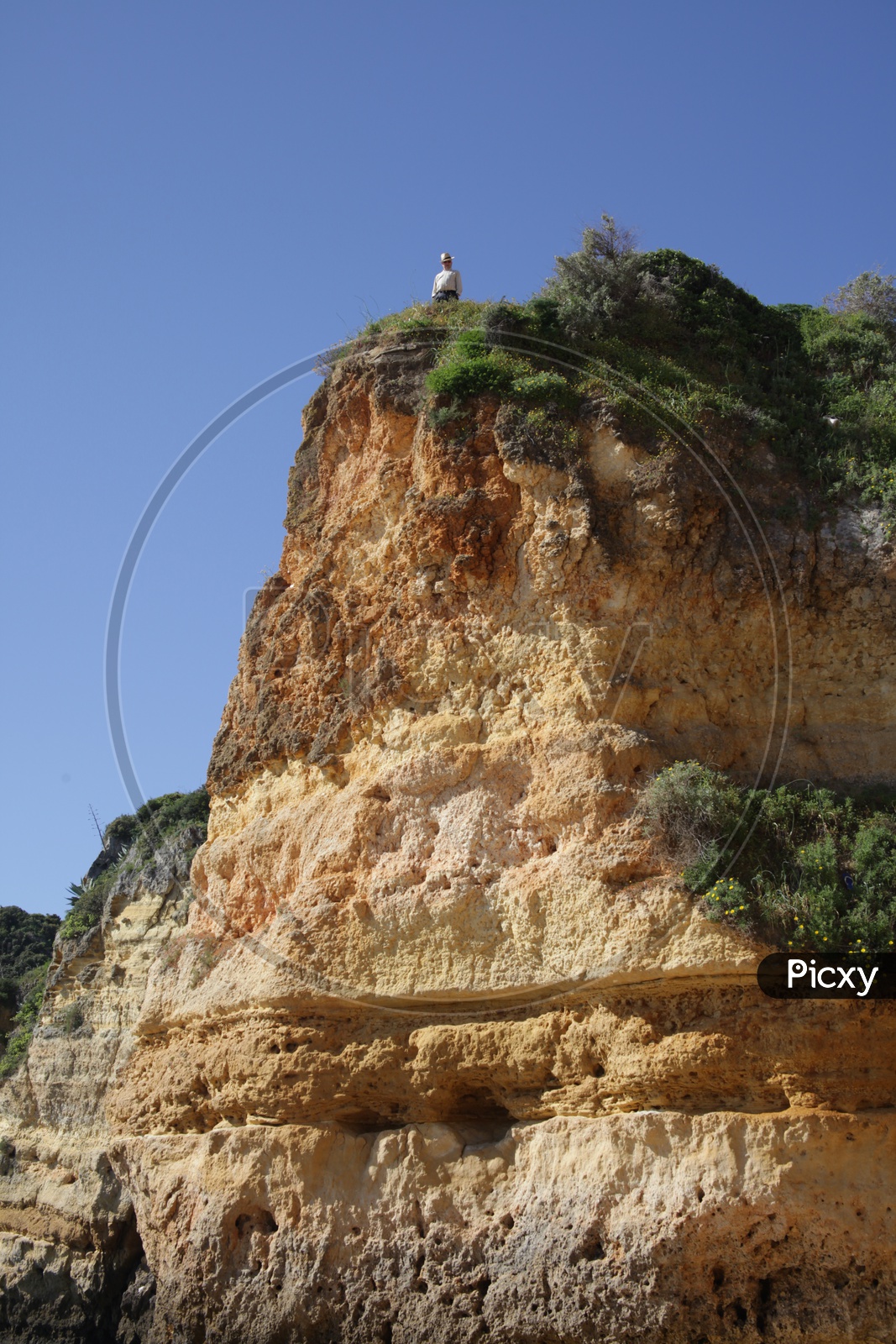a person standing on the top of the cliff