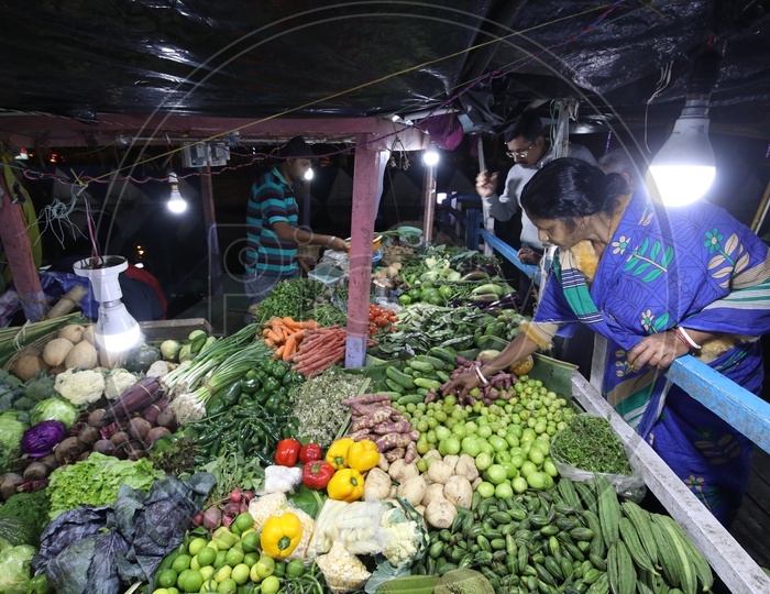 people shopping for vegetables under LED lights