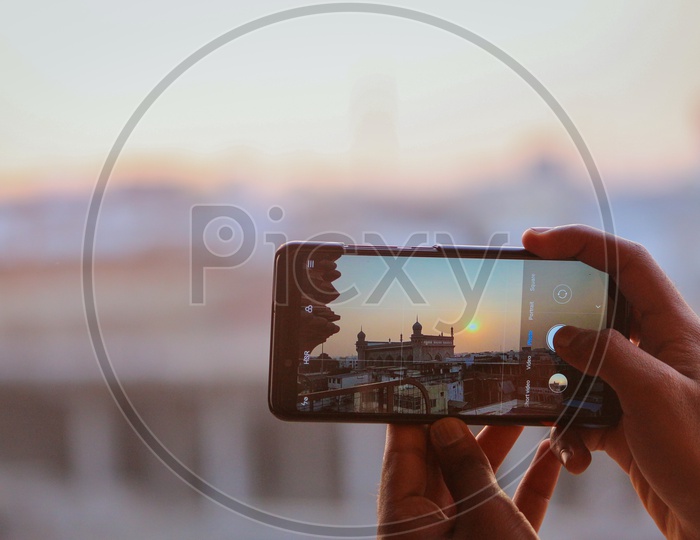 Person shooting sunset at Mecca Masjid from the Charminar using Redmi Note 5 Pro mobile
