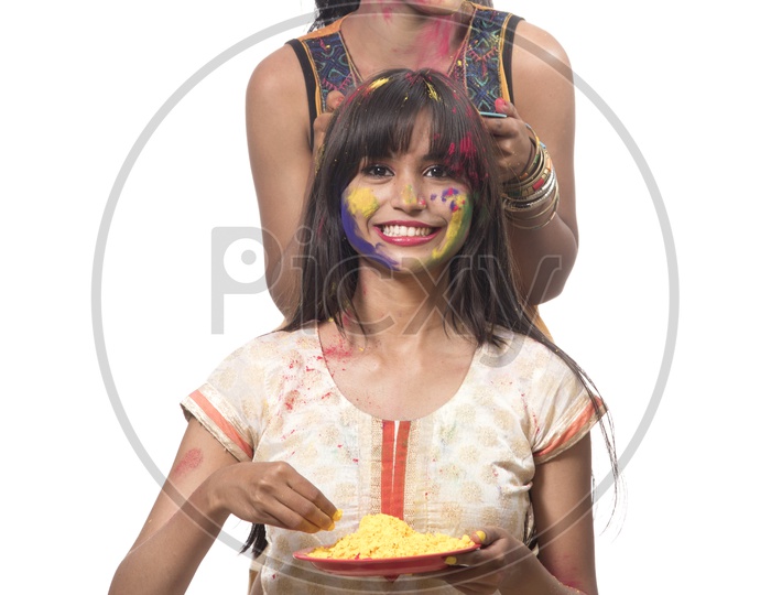 Happily Smiling Young Indian Girls Celebrating  With Colours