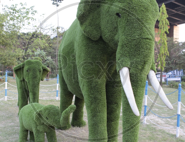 An Elephant and its babies sculptures covered with grass