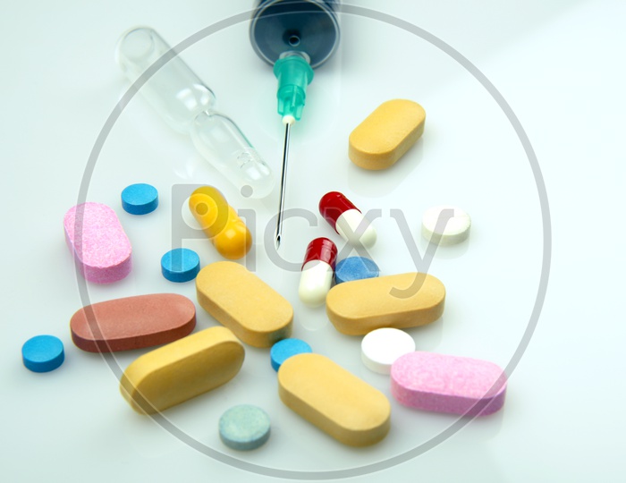 Various Painkiller pills and syringe on white background