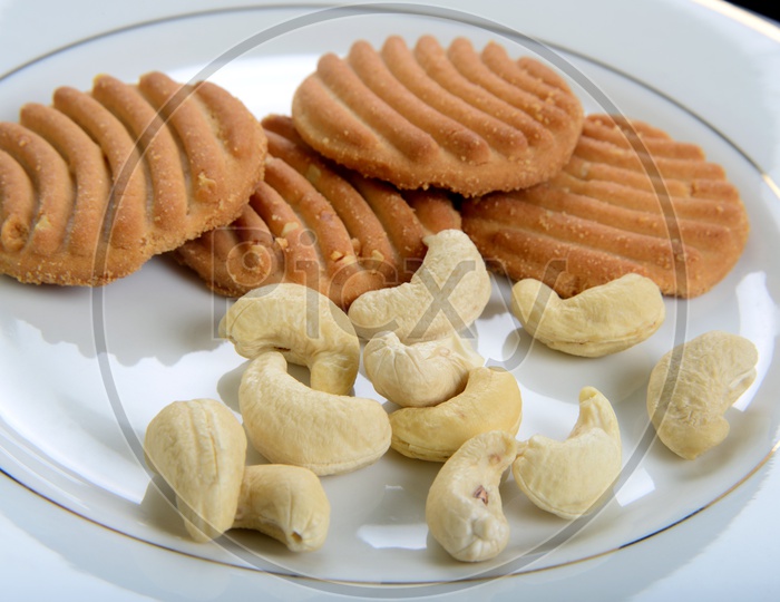 Sweet cookies or biscuits and nutritious cashew nuts in a plate