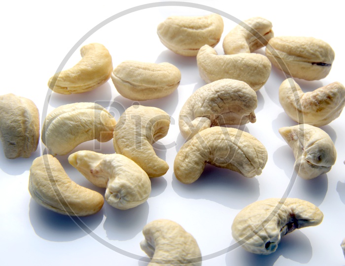 Nutritious cashew nuts scattered on white background